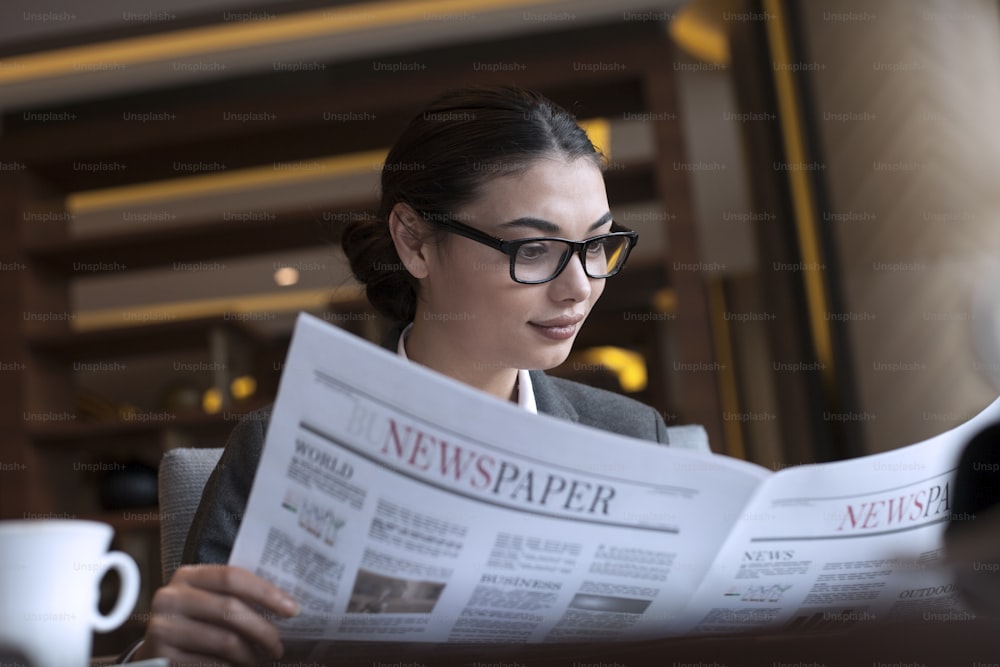 Mujer de negocios leyendo un periódico
