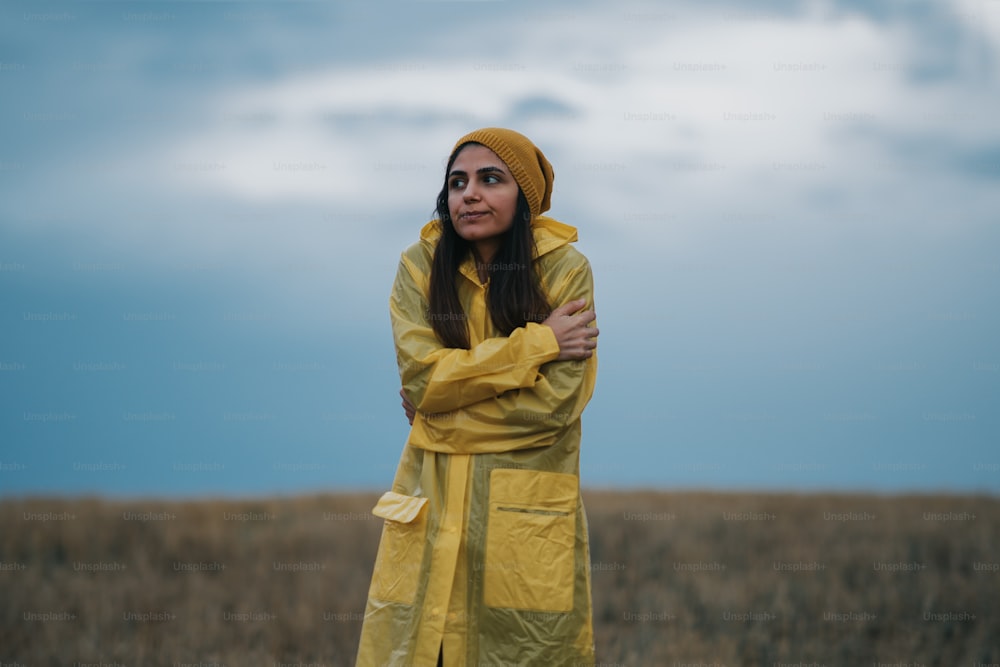 Young girl wearing a yellow raincoat in rainy and cold day