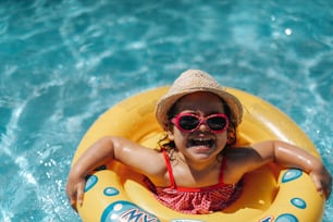 Niño en piscina con anillo. Vacaciones de verano con niños