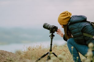 young woman shooting with camera at morning.Tripod and mirrorless camera.