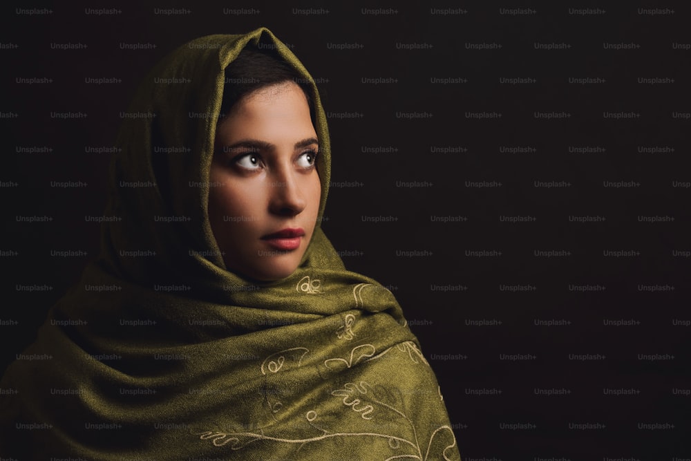 녹색 머리 스카프를 두른 무슬림 여성의 초상화.