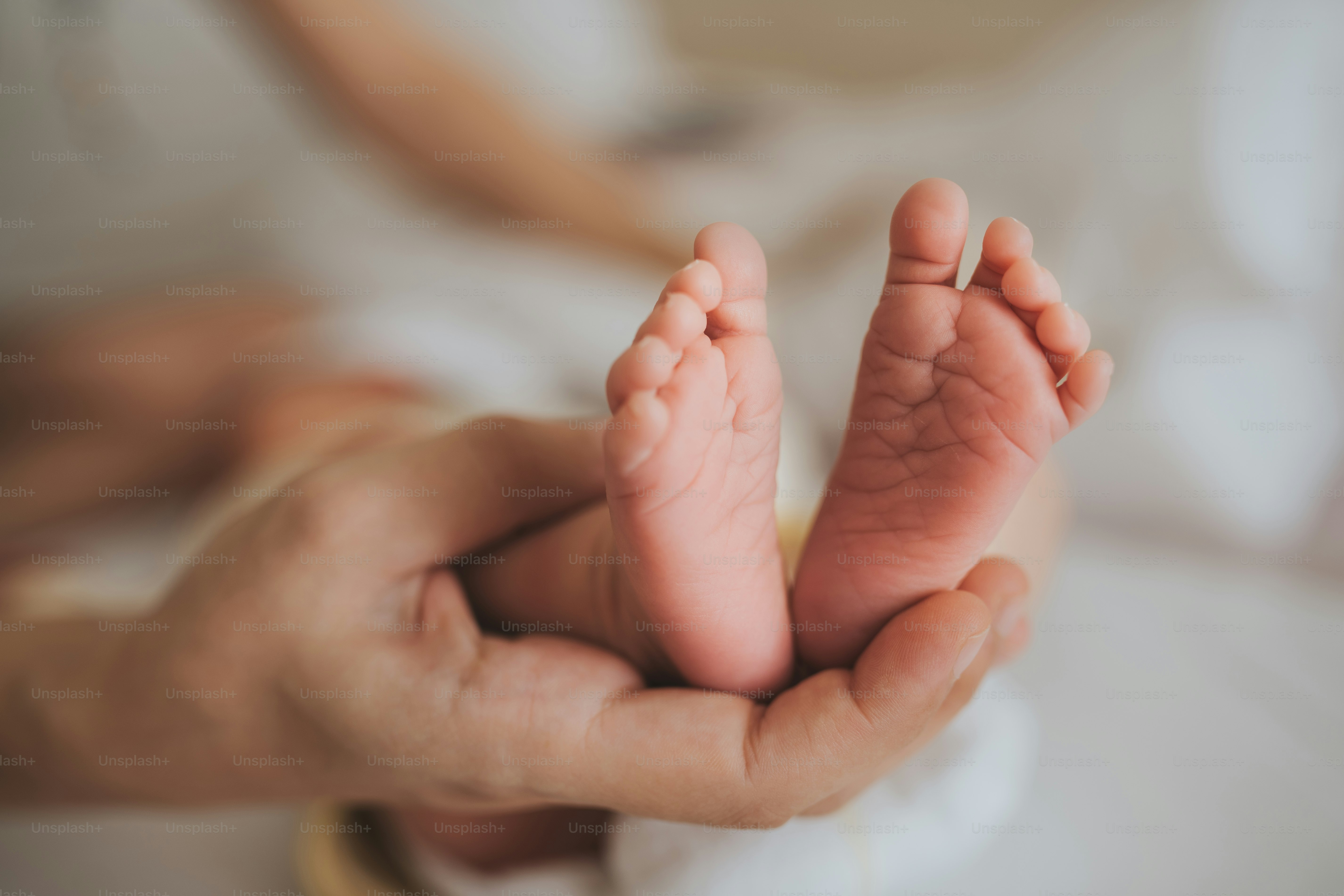 Ibu memegang kaki bayi yang baru lahir. Konsep perawatan kulit.