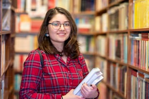 지적 십대 소녀는 책을 선택하고 도서관이나 서점에서 책을 고른다