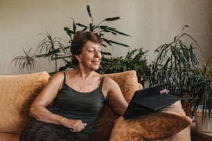 Femme âgée heureuse utilisant l’appel vidéo sur tablette et parlant avec la famille. Chat vidéo distanciation sociale. Rester à la maison sauve des vies du coronavirus covid-19. Auto-isolement.