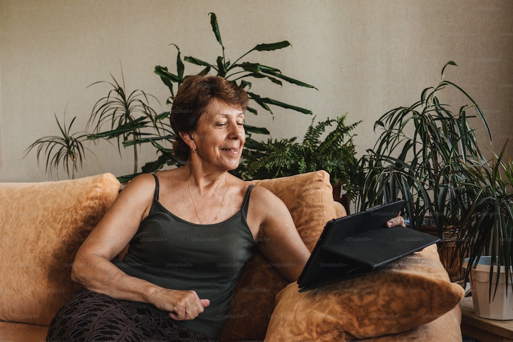 Donna anziana anziana felice che usa la videochiamata tablet e parla con la famiglia. Distanziamento sociale in video chat. Resta a casa per salvare vite dal coronavirus covid-19. Autoisolamento.