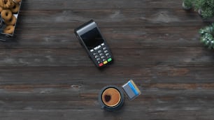 un teléfono celular sentado encima de una mesa de madera junto a una taza de café