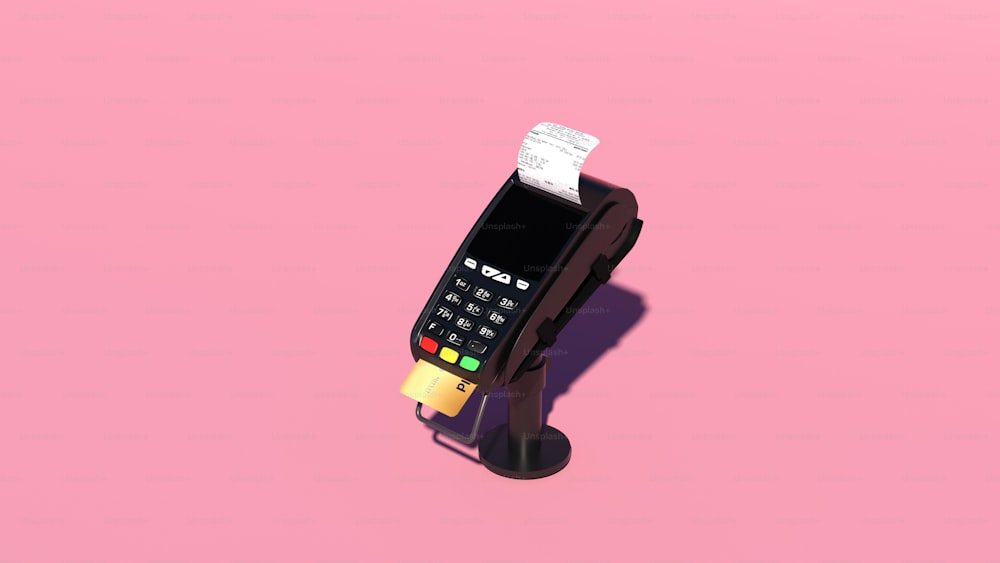 une calculatrice posée sur une surface rose