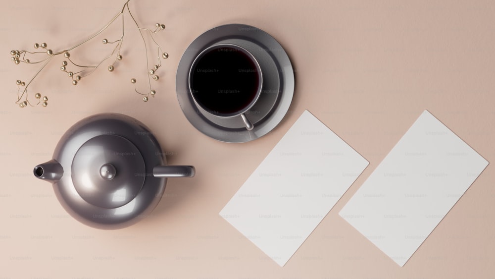 a cup of coffee next to a teapot and a piece of paper