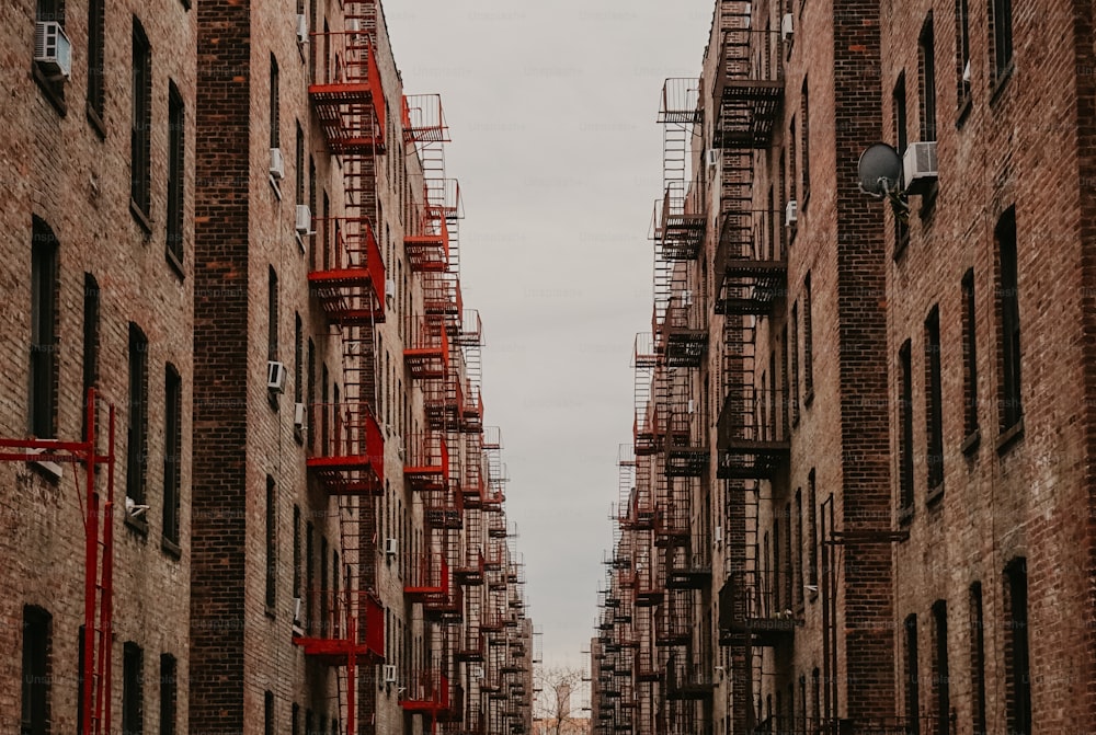 a couple of people walking down a street next to tall buildings