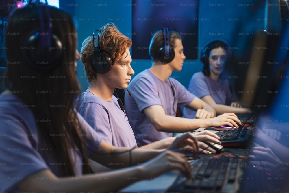 Team of teenage gamers playing in multiplayer PC video game on a eSport Tournament. Captain giving commands to his colleagues, while trying strategically win the game