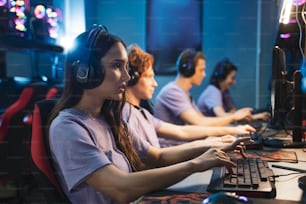 Jugadores profesionales en auriculares para juegos jugando en videojuegos de estrategia en las computadoras. Participan en el torneo de juegos cibernéticos en línea, jugando en casa o en un cibercafé