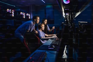 Une jeune équipe concentrée de joueurs professionnels se sent excitée en jouant ensemble à des jeux de cybersport en ligne au cybercafé