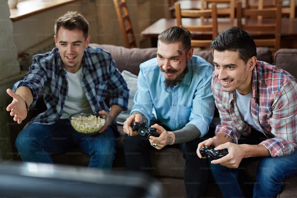 Three happy guys playing video game in team