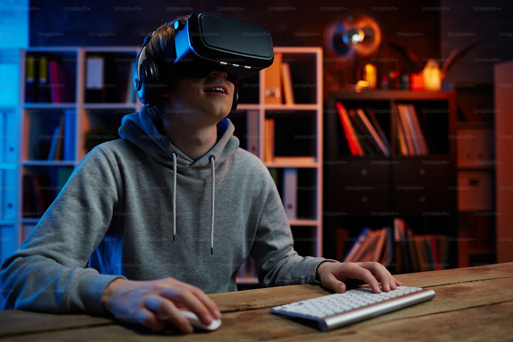 Contemporary guy in virtual reality headset playing video game