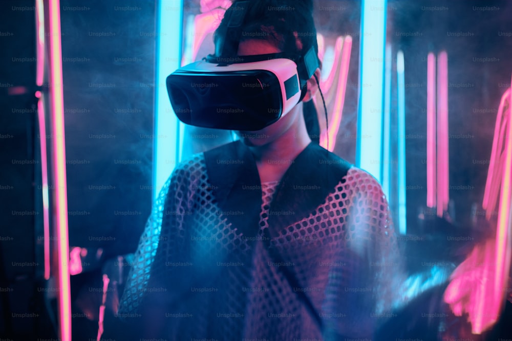 Retrato da menina que usa óculos de realidade virtual. Ela está cercada de luz neon. Conceito de Ponto de Vista de Realidade Virtual