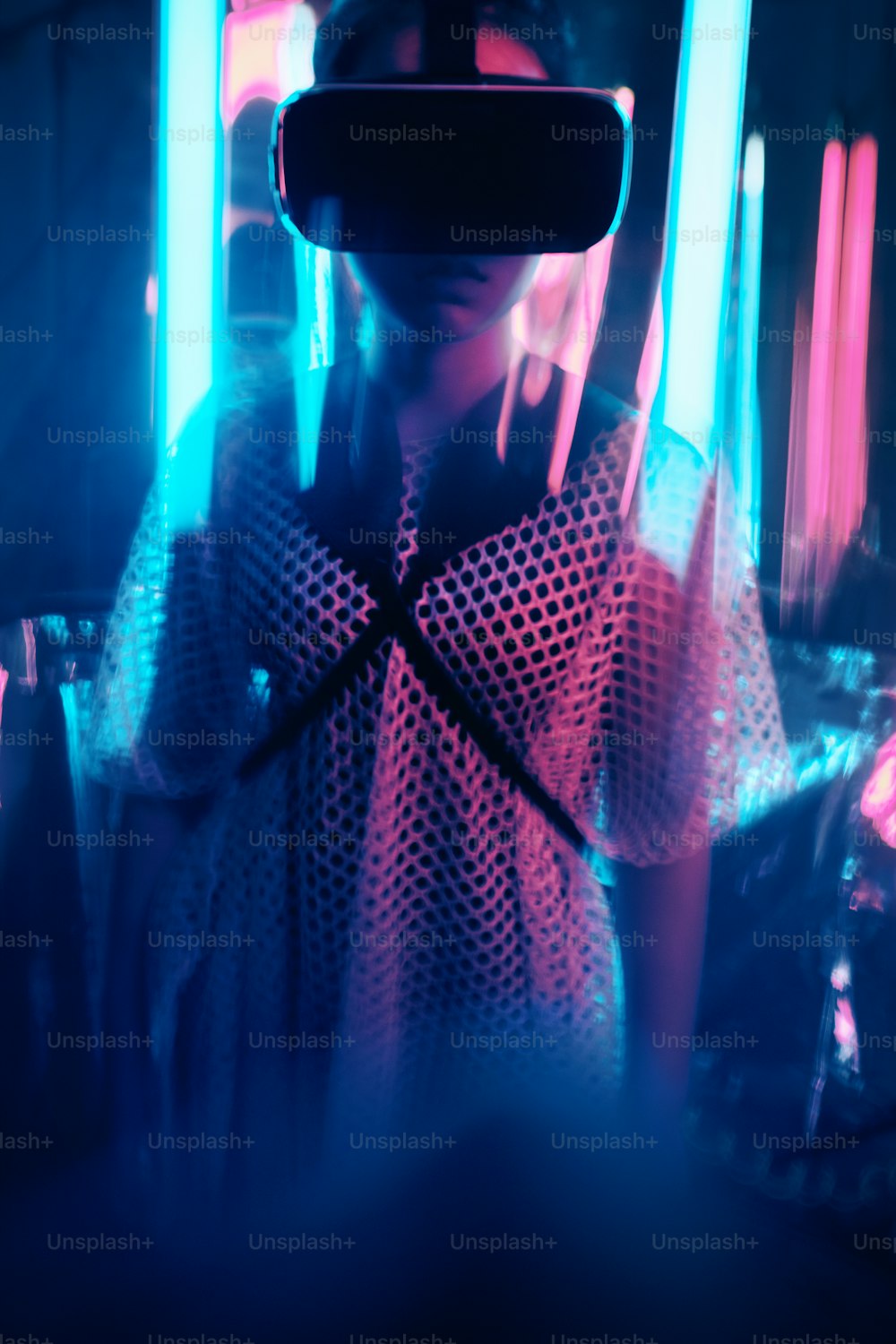 Ritratto di giovane ragazza che indossa occhiali per la realtà virtuale. È circondata da luce al neon. Concetto di punto di vista della realtà virtuale