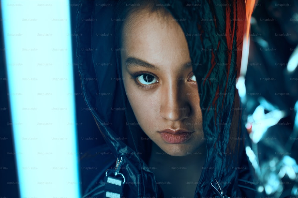 Retrato futurista do adolescente asiático em luz neon. Ela é seriour, ousada, cyberpunk garota da moda