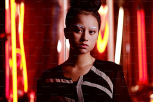 Retrato futurista de adolescente asiático em luz neon com espada como lâmpadas. Ela é seriour, ousada, cyberpunk garota da moda com sobrancelhas brancas