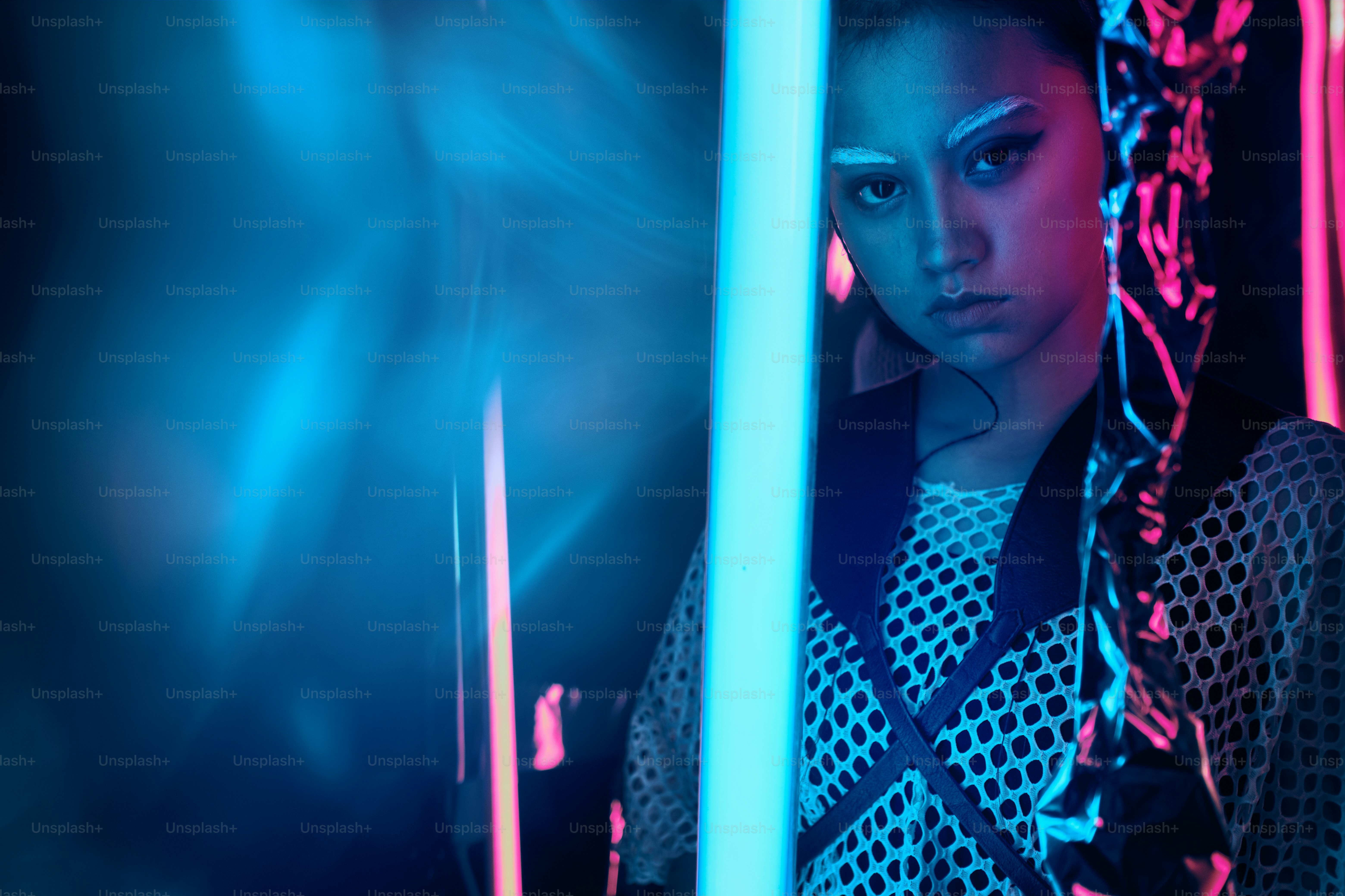 Potret futuristik remaja asia dalam cahaya neon dengan lampu seperti pedang. Efek noda neon diterapkan di depan. Dia adalah gadis modis cyberpunk, berani, dengan pakaian jaring, alis putih