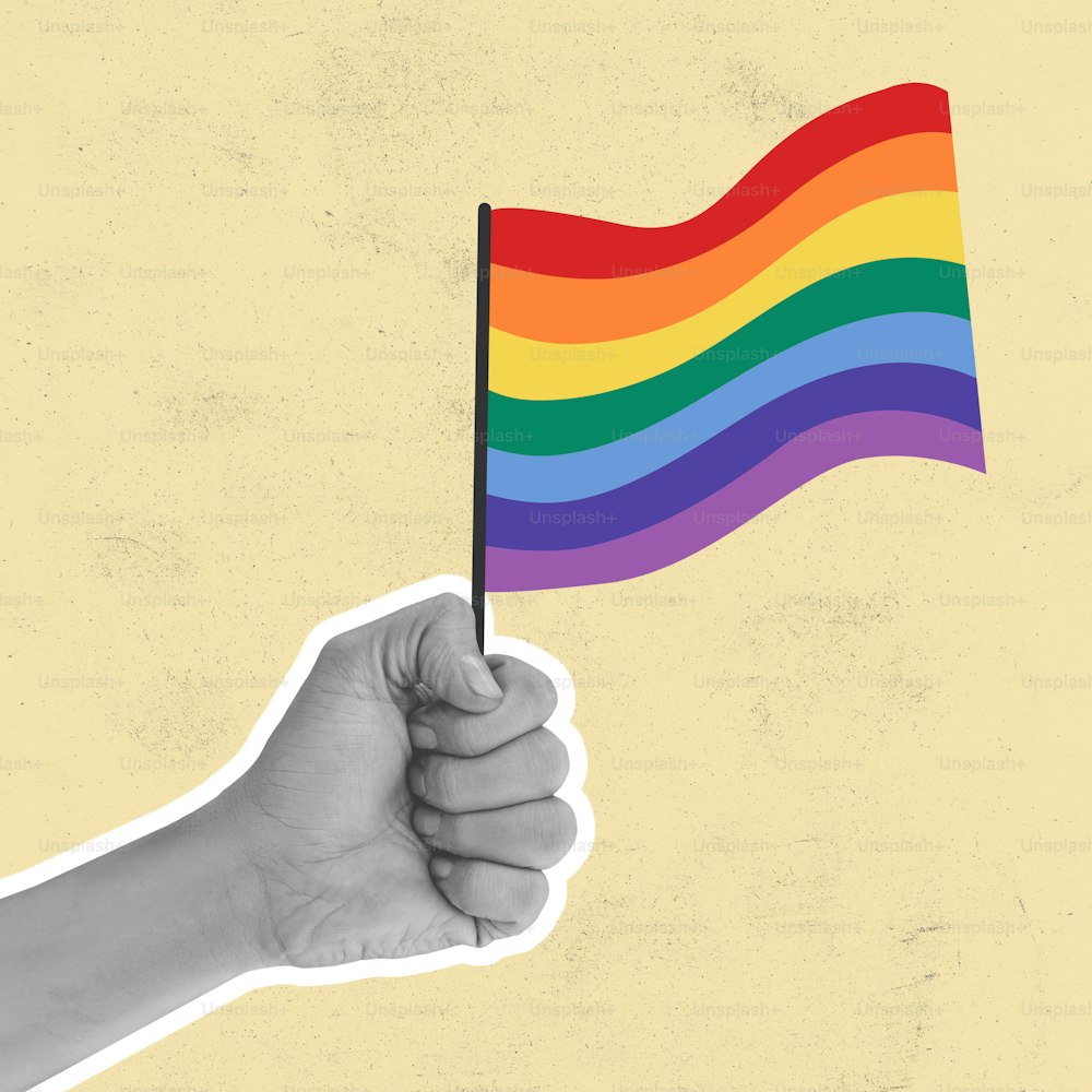 Igualdad, paz y amor. Mano sosteniendo la bandera LGBT del arco iris contra un fondo claro, obra de arte. Concepto de relación humana, comunidad, diversidad, simbolismo, surrealismo. Redes sociales, problemas, unidad.