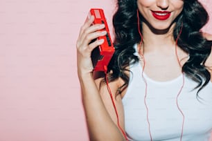 partial view of smiling woman with retro music player on pink backdrop