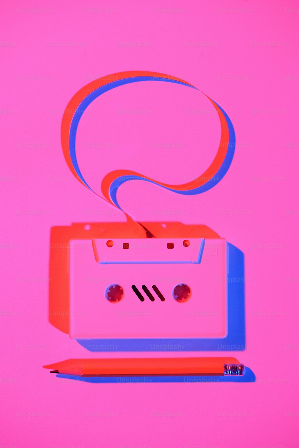 toned pink picture of pencil and retro audio cassette with speech bubble