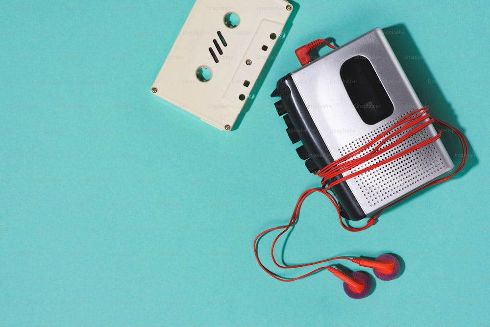 flat lay with retro audio cassette, cassette player and earphones isolated on blue