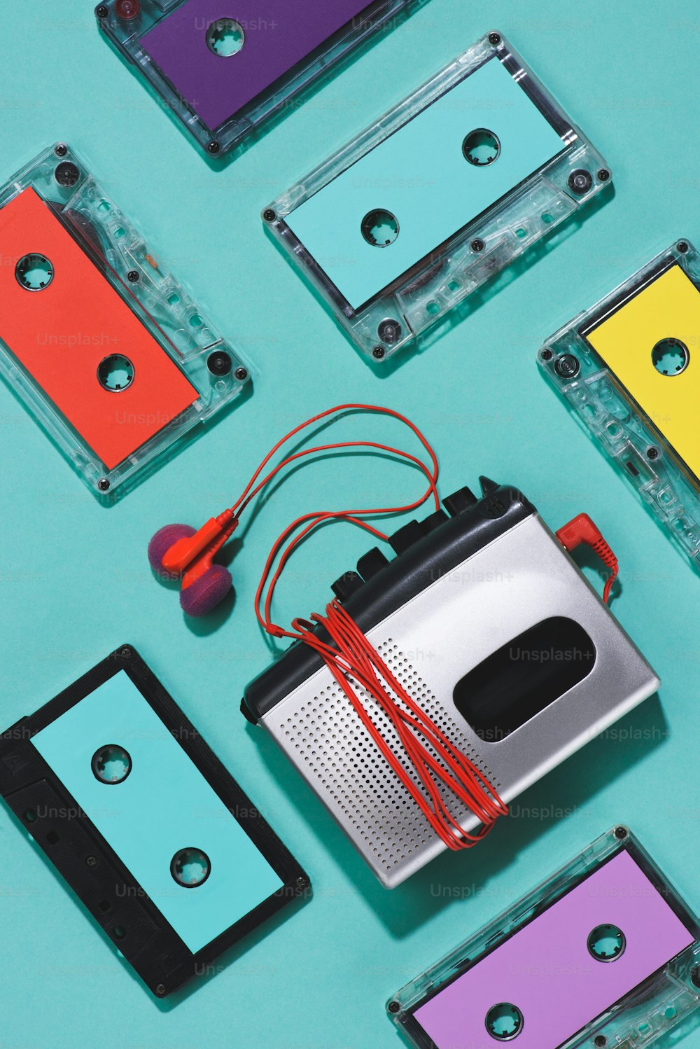 화려한 복고풍 오디오 카세트, 카세트 플레이어 및 파란색으로 분리된 이어폰이 있는 플랫 레이