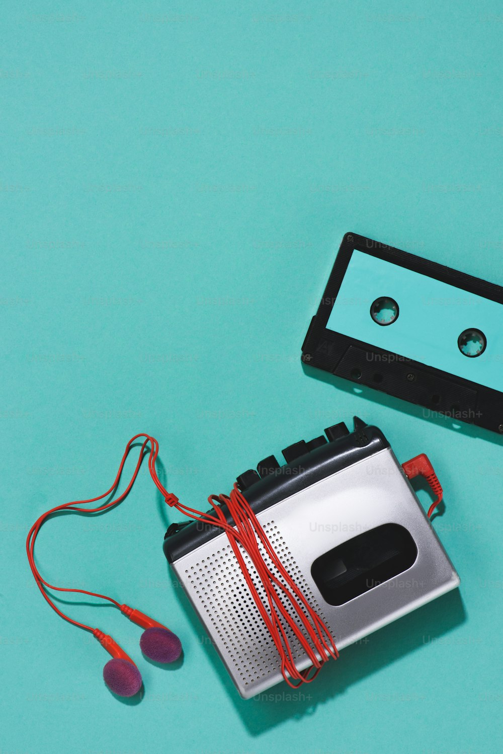 flat lay with retro audio cassette, cassette player and earphones isolated on blue