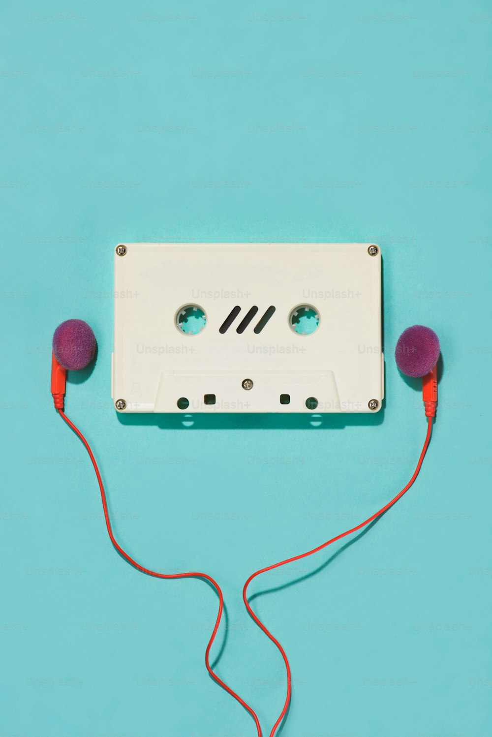 pose plate avec cassette audio rétro blanche et écouteurs isolés sur bleu