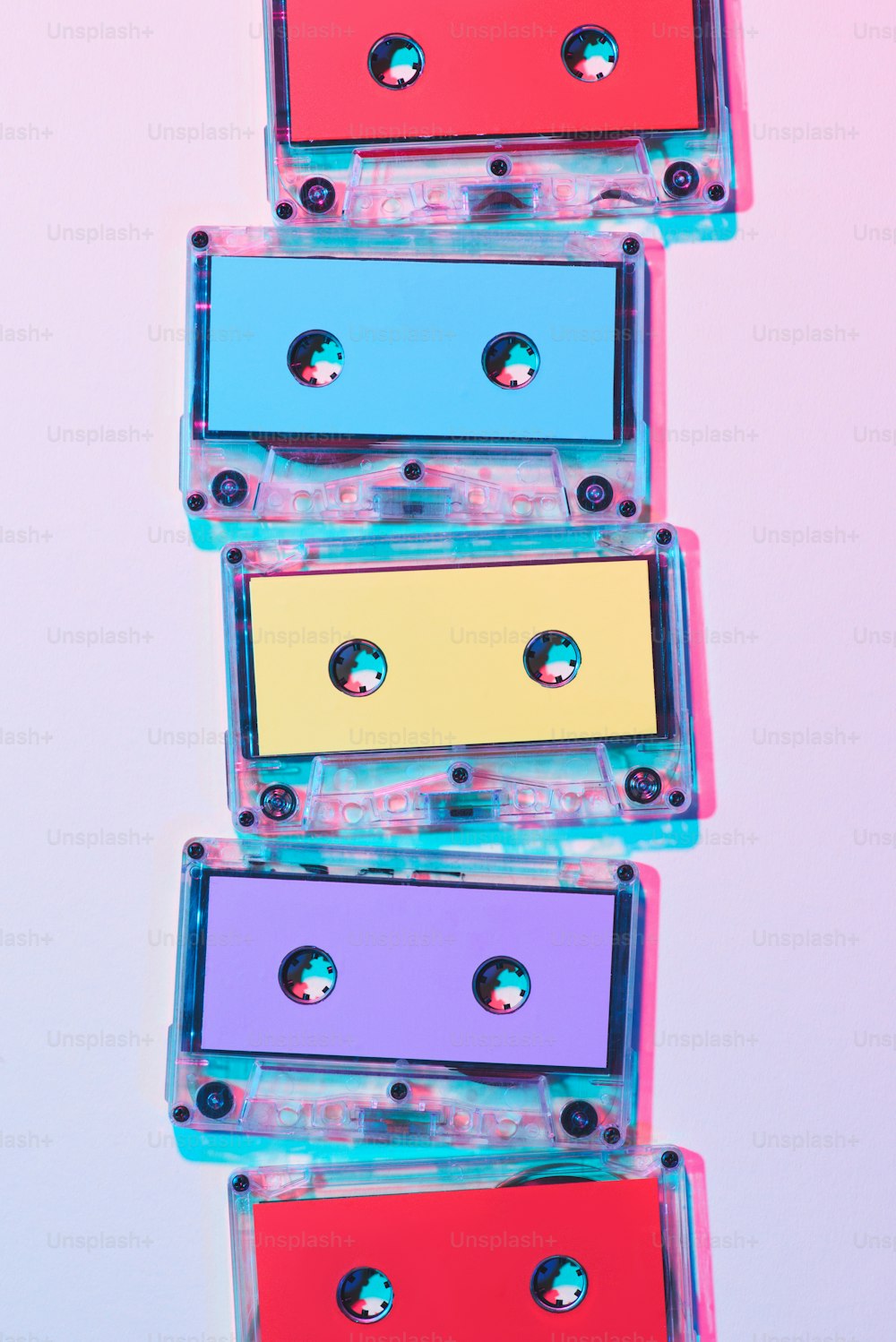 Vista superior de casetes de audio coloridos dispuestos sobre fondo púrpura