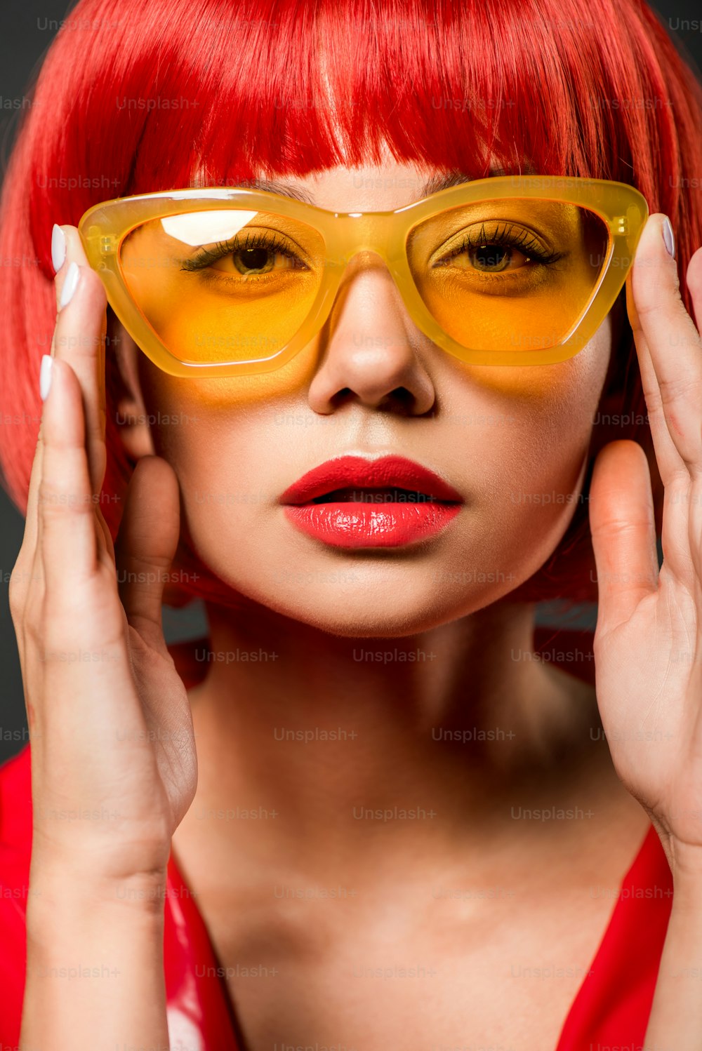 빈티지 노란색 선글라스를 끼고 카메라를 보고 있는 아름다운 젊은 여성의 클로즈업 초상화