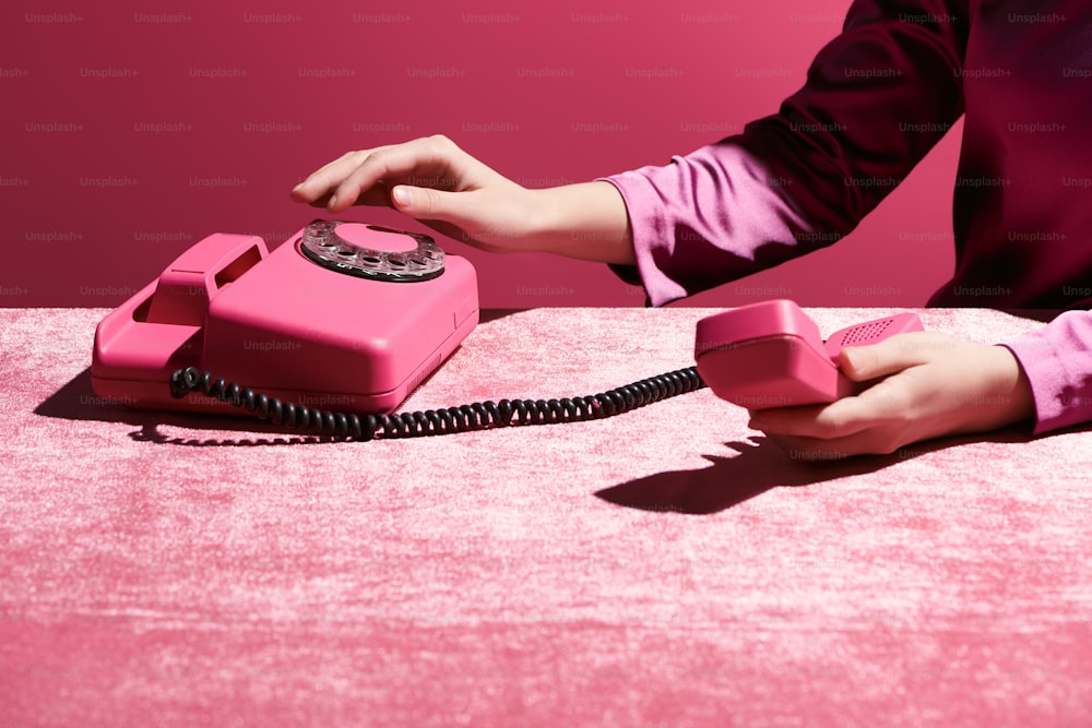 분홍색, 소녀 같은 개념에 고립된 벨루어 천에 복고풍 전화기를 사용하는 여성의 자른 모습