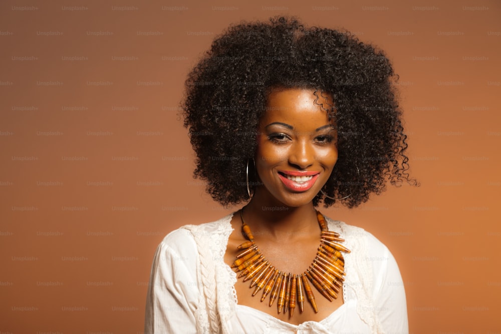 Vintage 70s fashion afro woman. White shirt and jeans against brown background.
