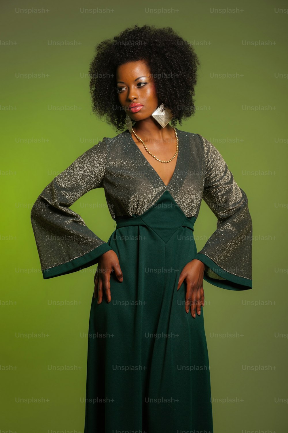 Sensuale retrò anni settanta moda afro donna con vestito verde. Sfondo verde.