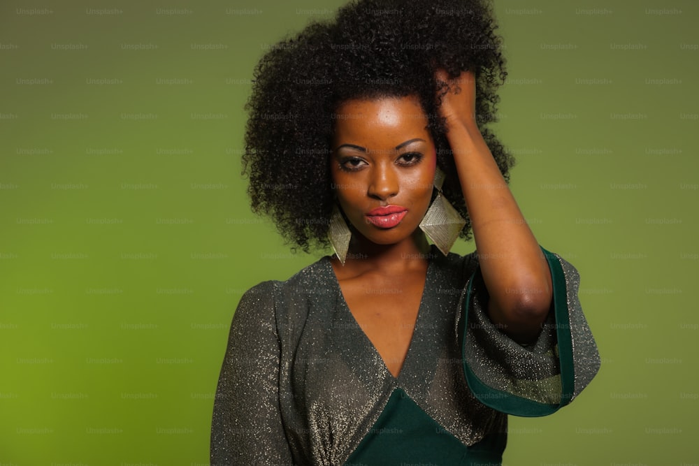 Sensuale retrò anni settanta moda afro donna con vestito verde. Sfondo verde.