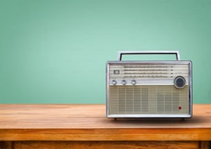 Old retro radio on table with vintage green eye light background