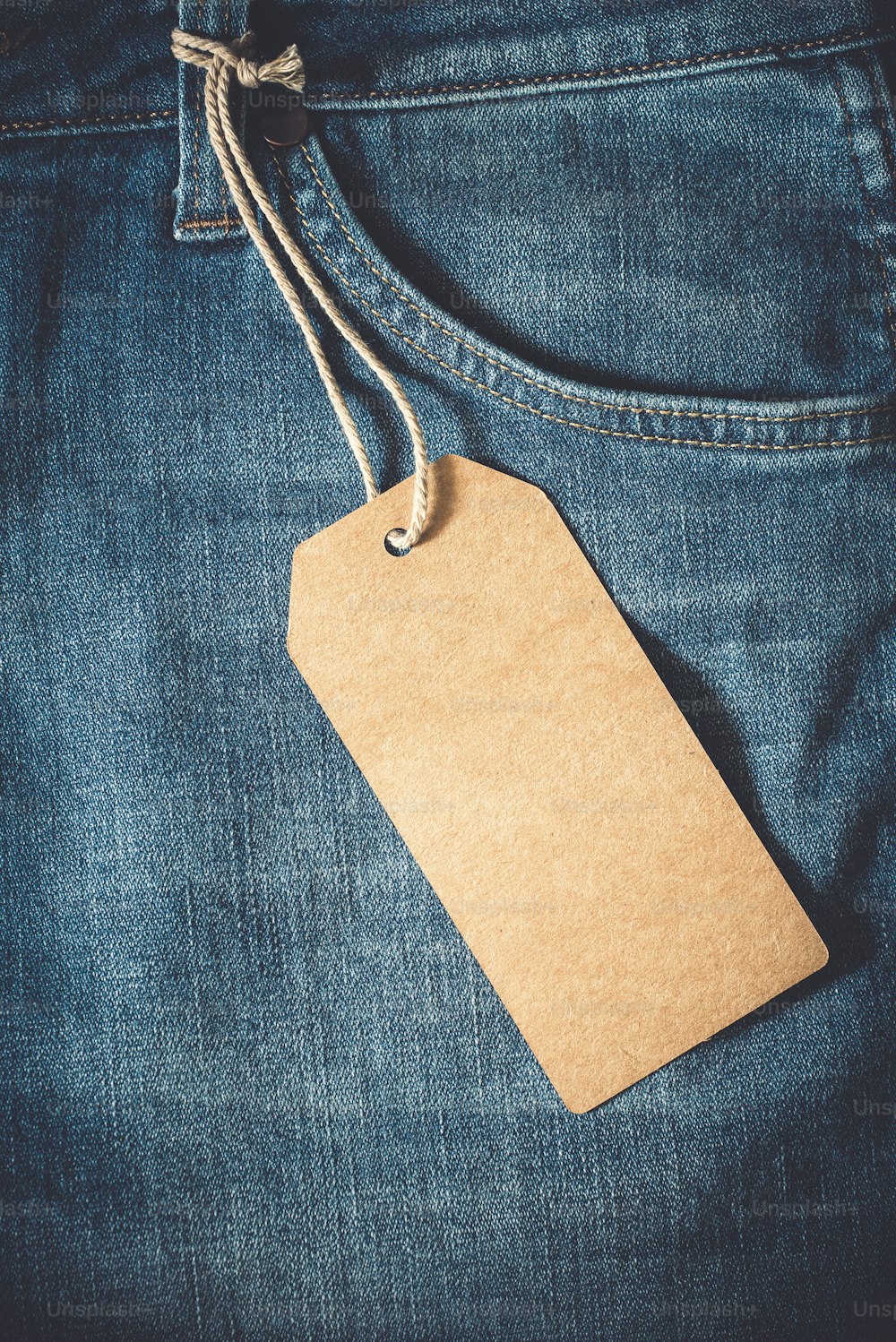 Empty brown paper tag of jean. vintage color effect style.