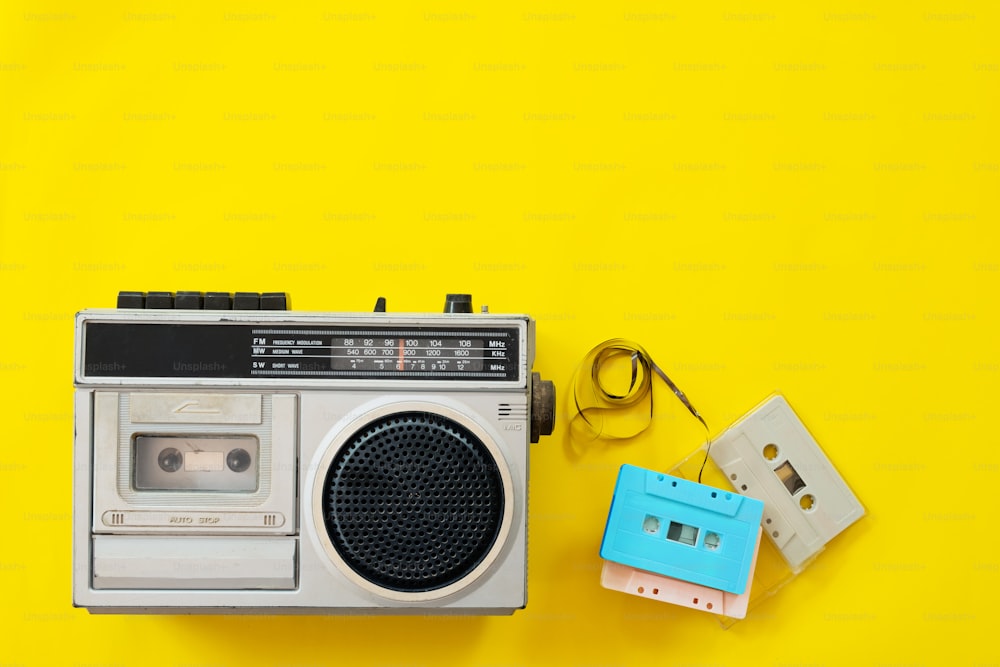 Radio vintage e lettore di cassette su sfondo giallo, posa piatta, vista dall'alto. Tecnologia retrò