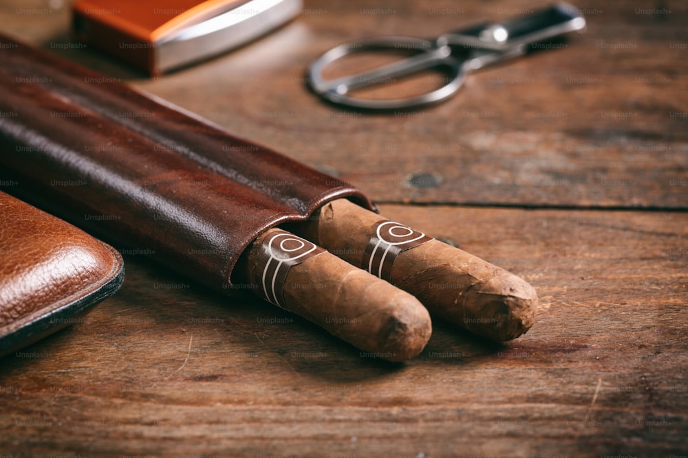 Cuban cigars in a leather case on wooden background, copy space