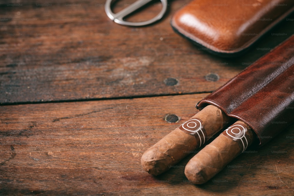 Cuban cigars in a leather case on wooden background, copy space