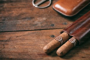 Cuban cigars in a leather case on wooden background, copy space