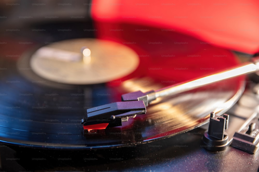 Technologie sonore rétro, jouez de la musique de fête vintage. Tourne-disque vinyle, fond disco néon. Aiguille sur le disque, vue rapprochée.