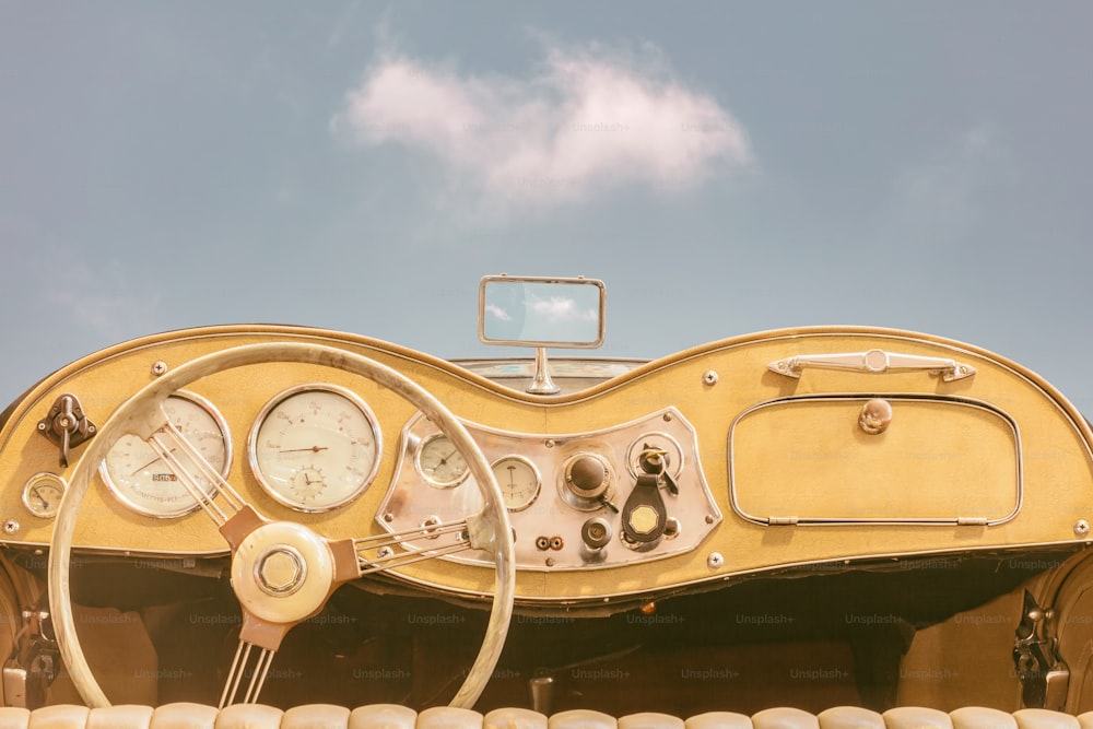 Vue du conducteur d’une voiture classique à cabriolet ouvert vintage à deux places devant un ciel bleu ensoleillé