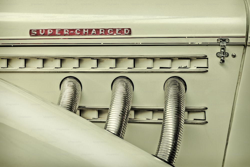 Retro styled image of the side view of a classic car with chrome exhausts