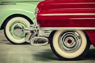 retro styled image of two vintage American cars parked next to each other