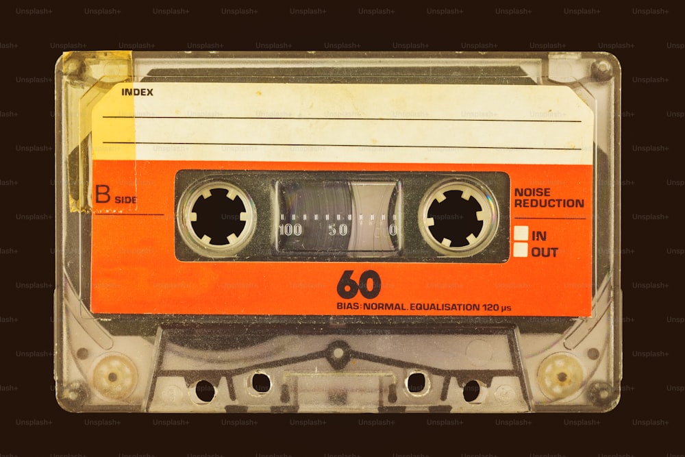 Vecchia cassetta compatta audio vintage davanti a uno sfondo marrone scuro