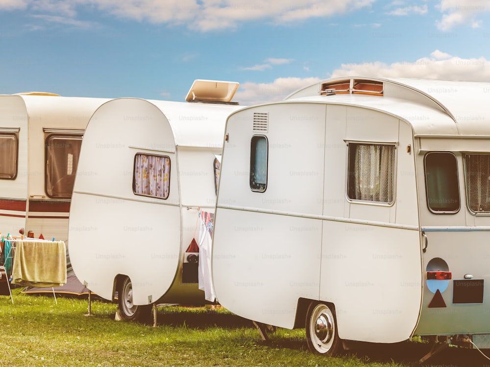 Row of three vintage restored caravans in front of a blue sky