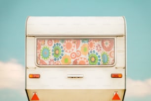 Vintage rear of a caravan with colourful seventies flower curtains