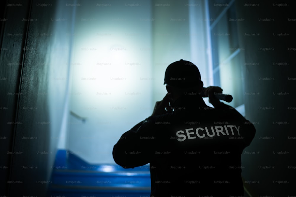 Security Guard Searching On Stairway With Flashlight